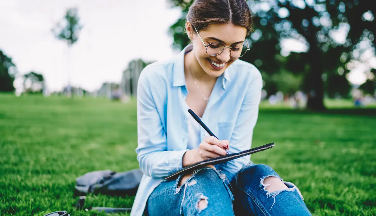 girl outside working on a reverse coloring page