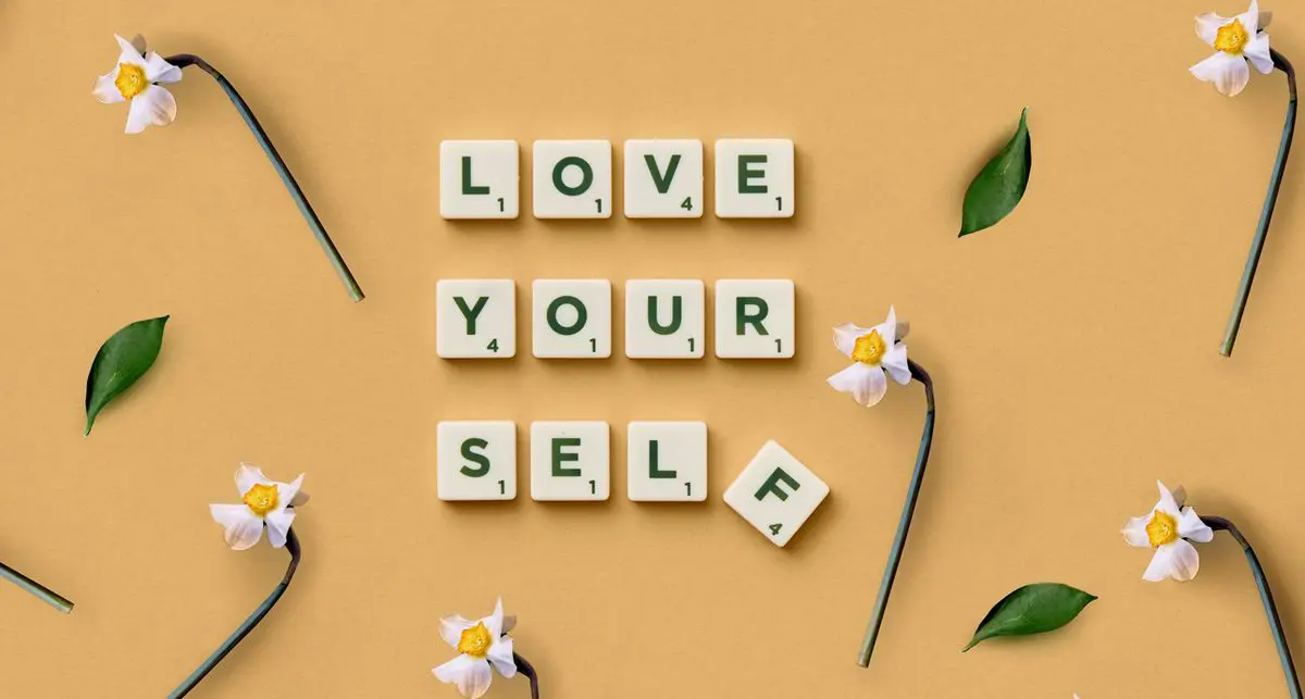 Finding gratitude in tough times — Love Yourself spelled in letter tiles among daffodils