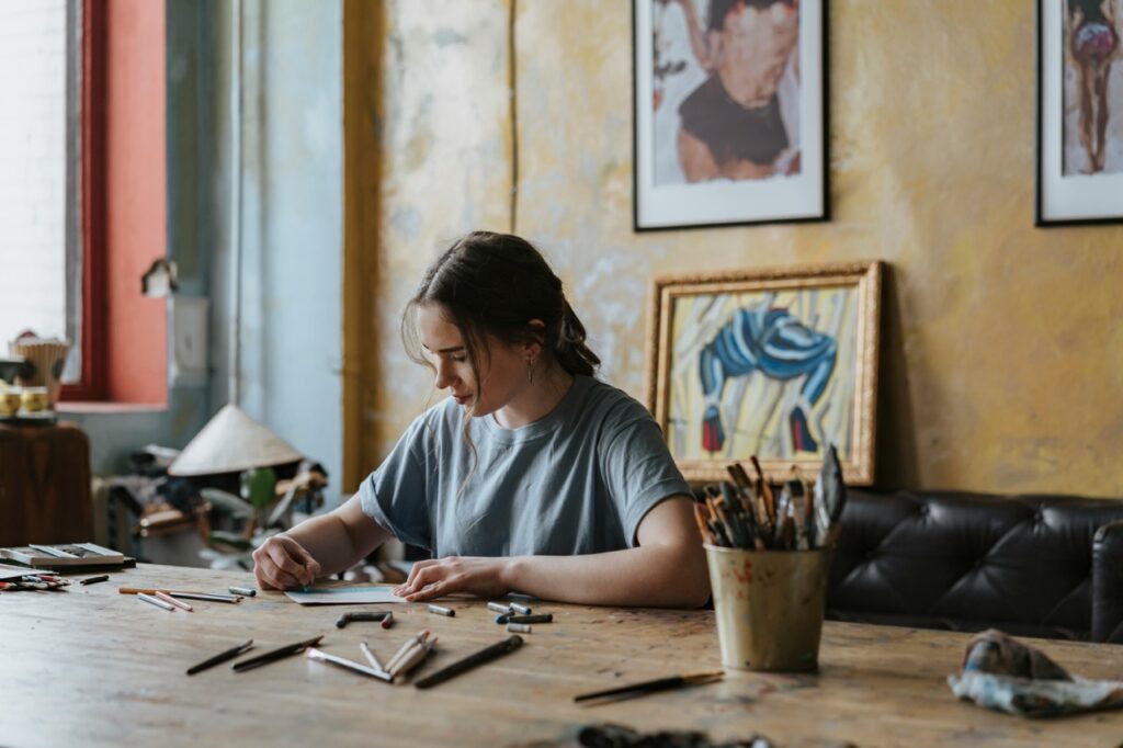 girl at rustic table doing art